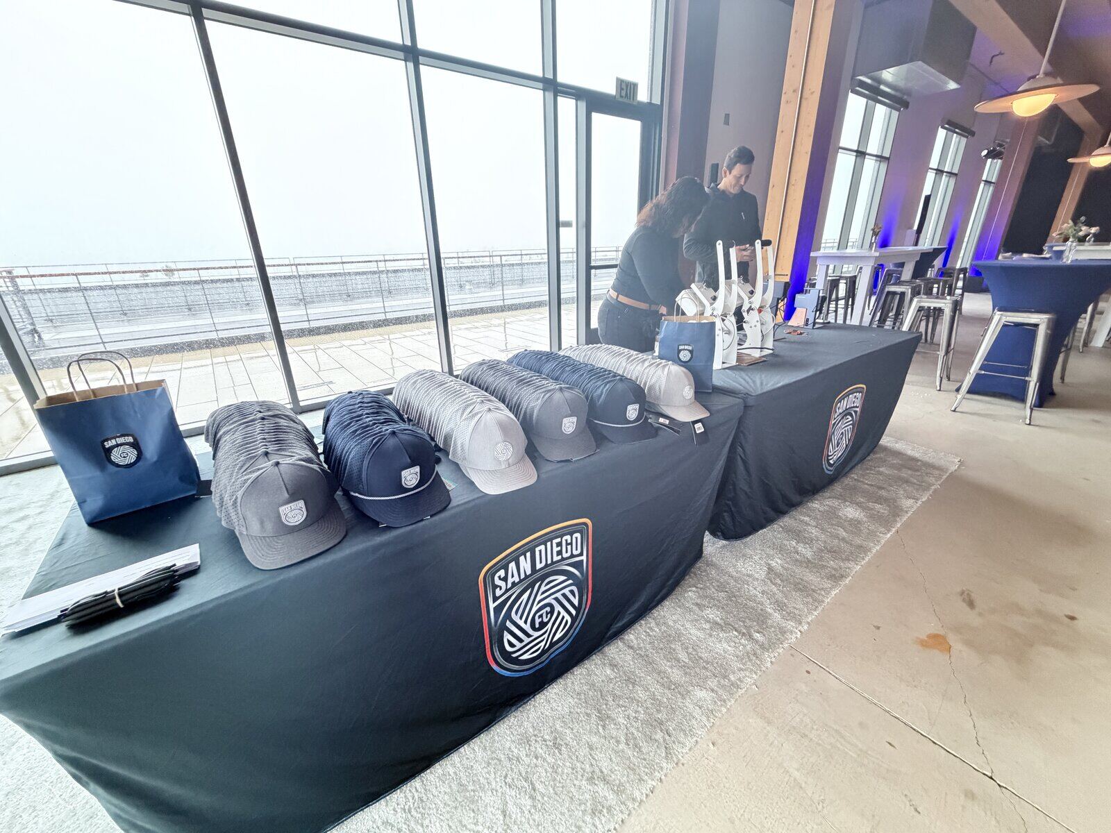 Rows of trucker caps staged on a hat bar table before doors open at a club launch