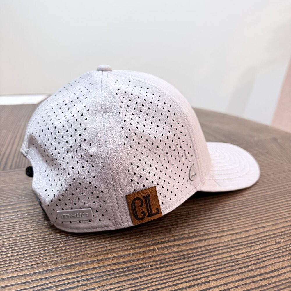 Premium performance trucker cap with a laser-engraved leather monogram patch